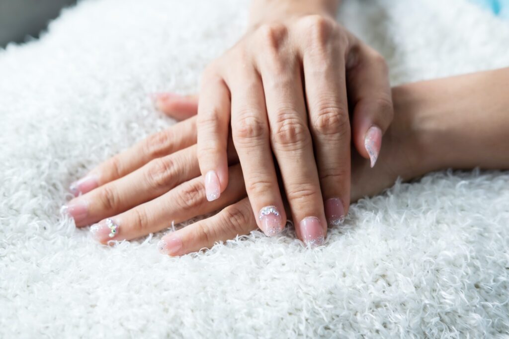 Beautiful manicure nails paint with glitter and varnish in nail salon